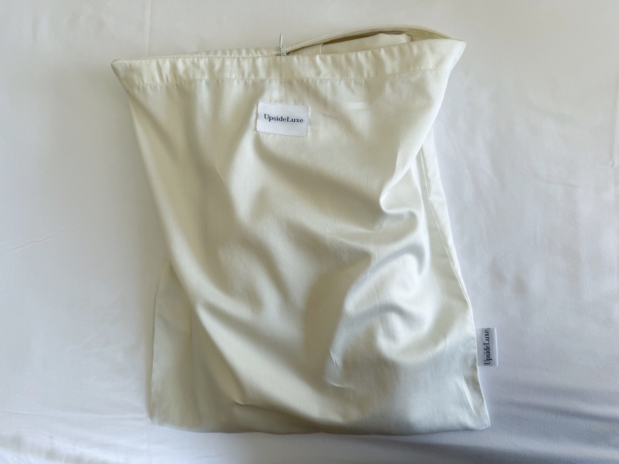 UpsideLuxe Sleep Sack folded inside its matching Supima cotton sateen packing envelope